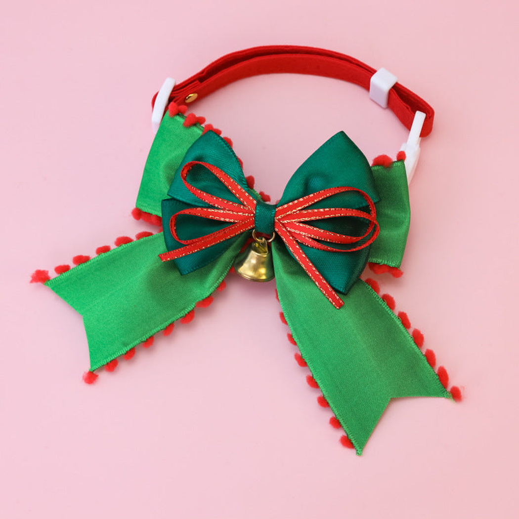 Trimmed Bow pet collar with a green bow, red looped trim, and a bell