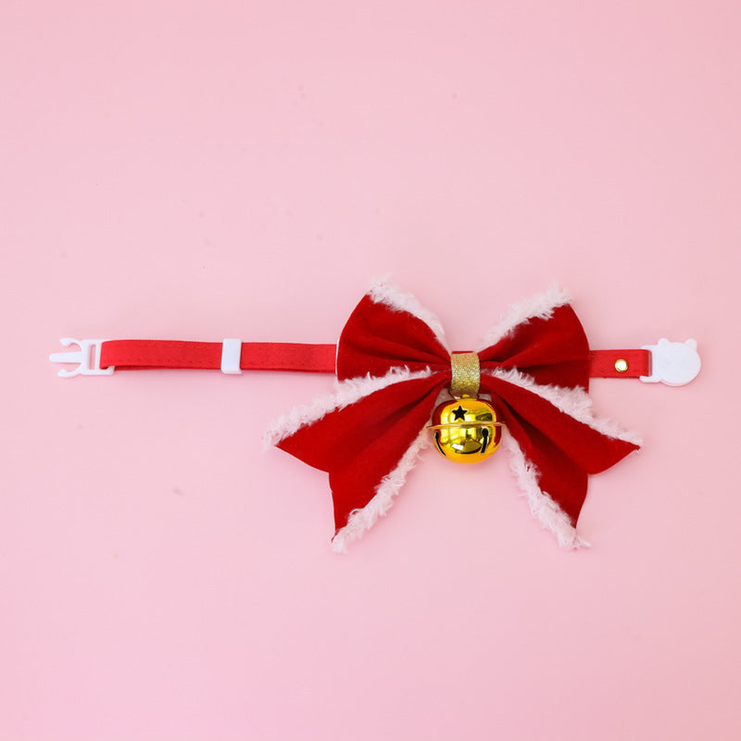 Red bow pet collar with white buckle and hanging gold bell, front view