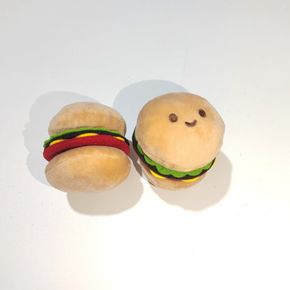 Moo plush hamburger cat toy lying on a white surface with visible stitching and colorful layers