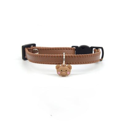 Side view of brown leather cat collar featuring a small bear charm and metal buckle