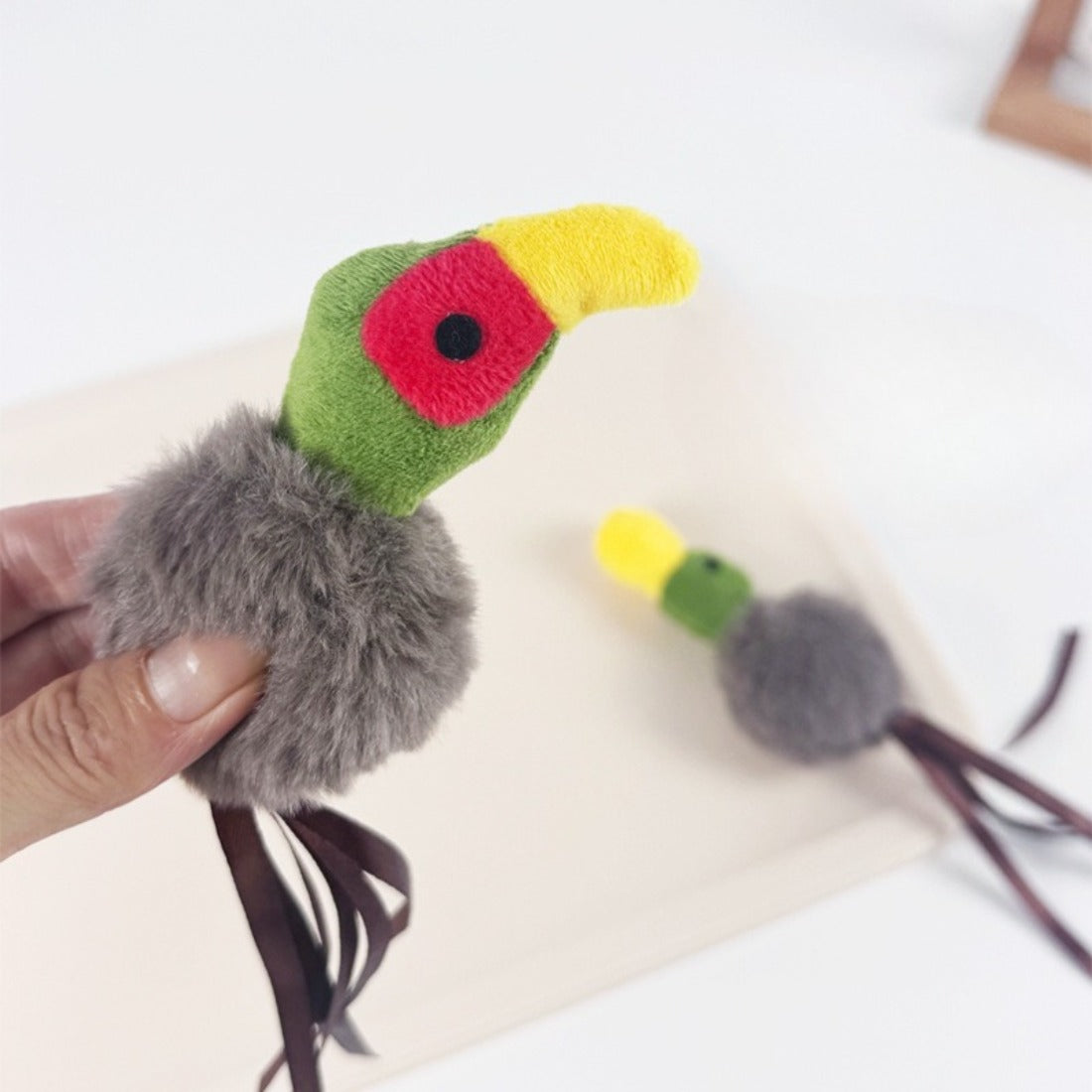 Close-up of Moo cat toy showing detailed feathers and plush texture