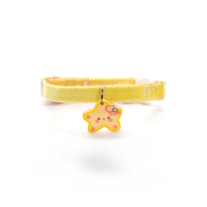 Close-up of gold star charm on Mokka Simple Star Charm Collar with textured background