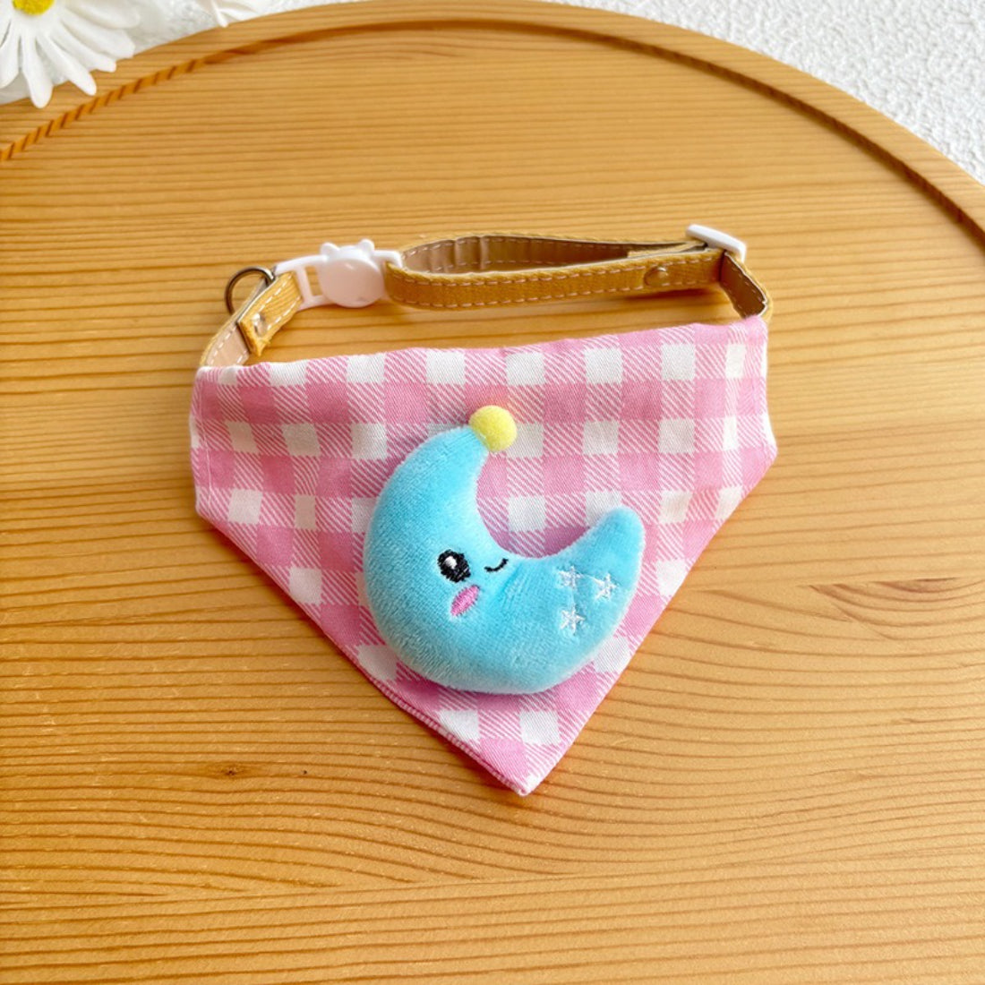 Pink gingham cat bandana displayed on a wooden surface