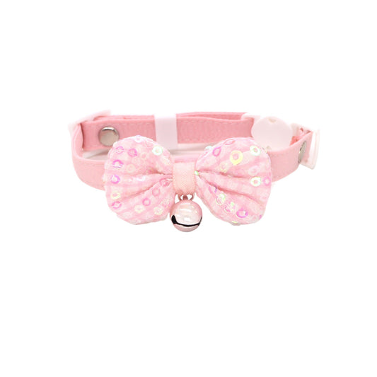 Close-up of pastel bow and bell detail on pink cat collar