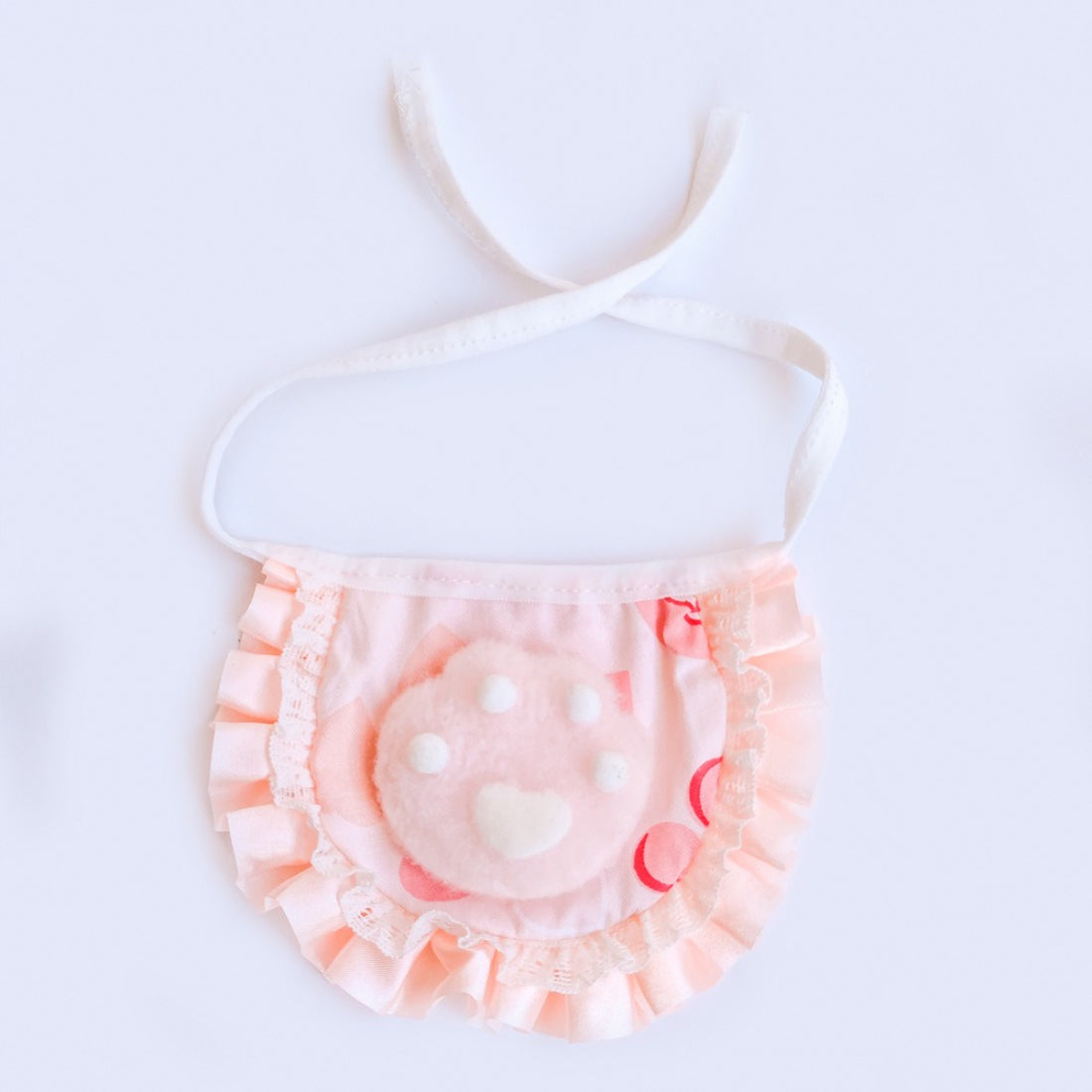 Mokka Ruffle Paw Cat Bib displayed on a cat mannequin highlighting adjustable neck strap