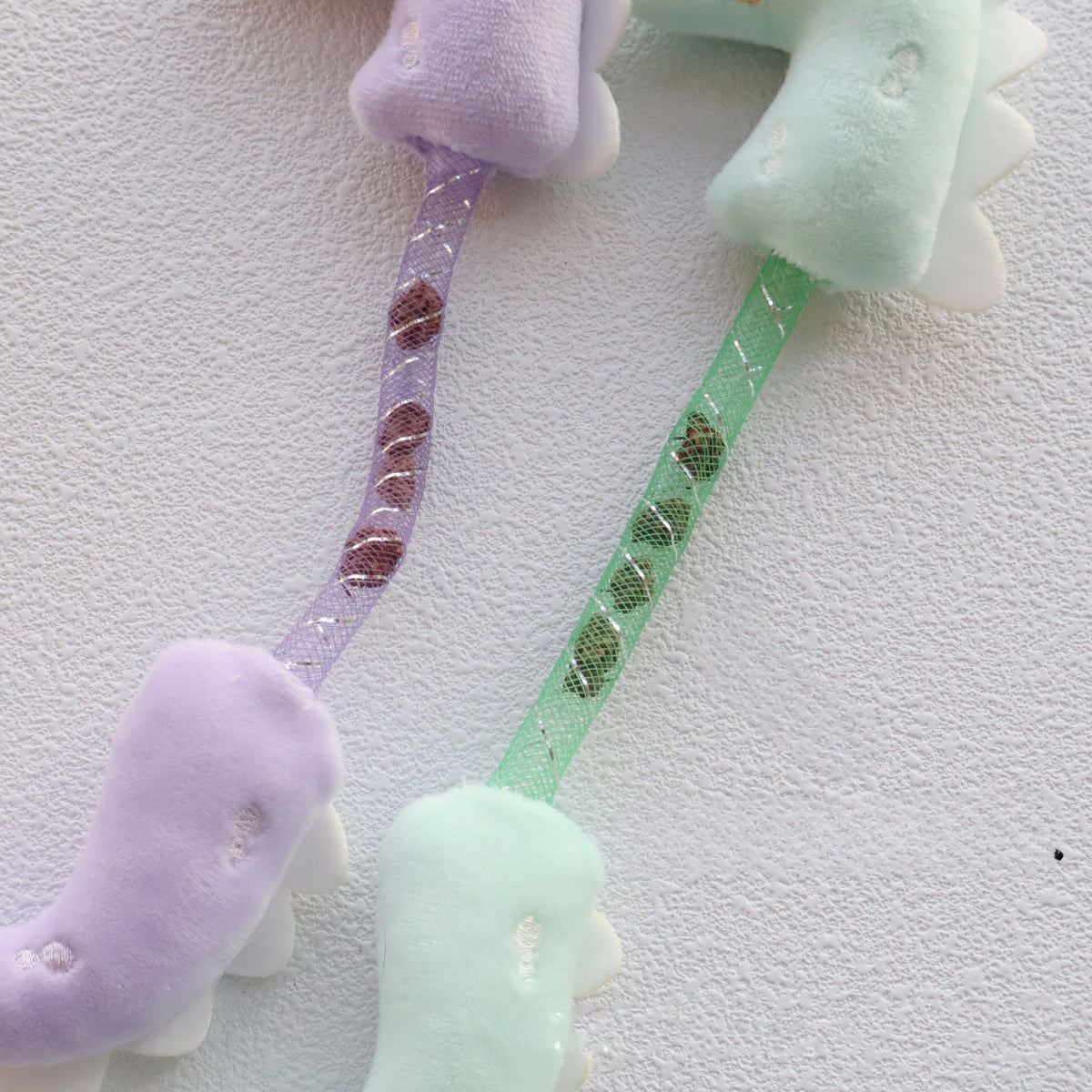 Moo Dinosaur cat toy held in hand displaying size and wiggly tail feature