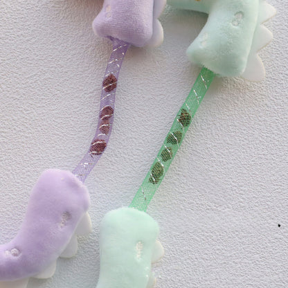 Moo Dinosaur cat toy held in hand displaying size and wiggly tail feature