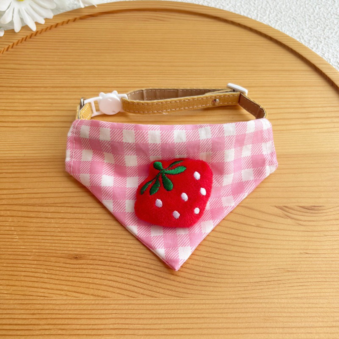 Pink gingham cat bandana tied in a knot on a cat