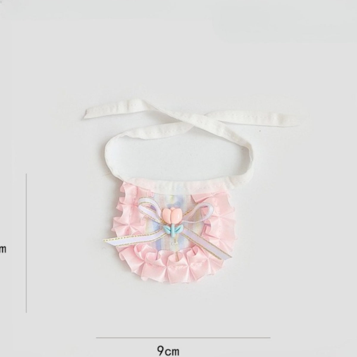Side view of cat wearing pastel ribbon bib highlighting ribbon detail and shape