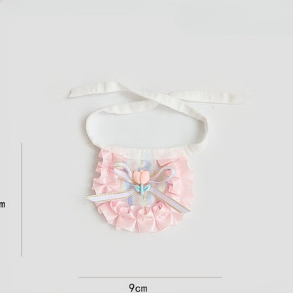 Side view of cat wearing pastel ribbon bib highlighting ribbon detail and shape