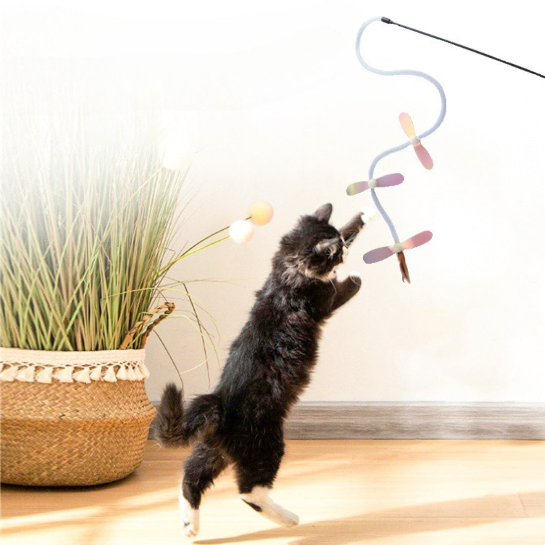 Moo Flutter Wing Cat Teaser Wand held by hand with feather wings visible