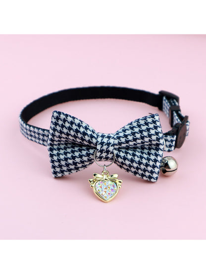 Mokka cat collar with black and white bow and bell on a light background