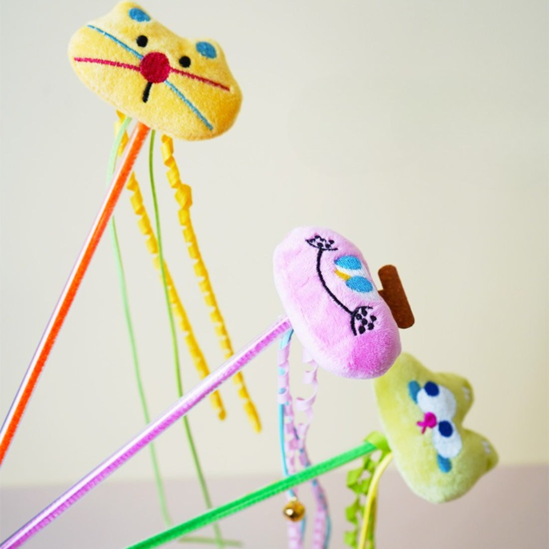 Moo plush cat teaser wand with feathers fanned out on a white background